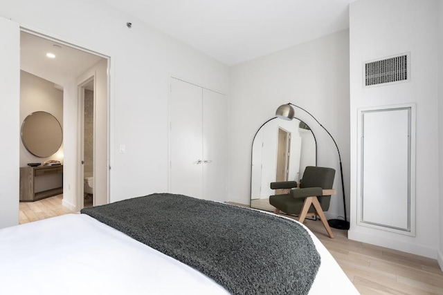 bedroom with recessed lighting, visible vents, a closet, and light wood finished floors