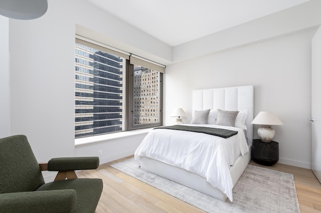 bedroom with baseboards and wood finished floors