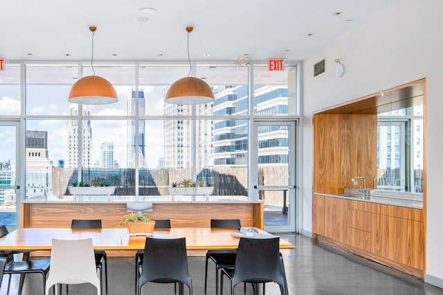 dining room featuring a wealth of natural light, a city view, a wall of windows, and visible vents