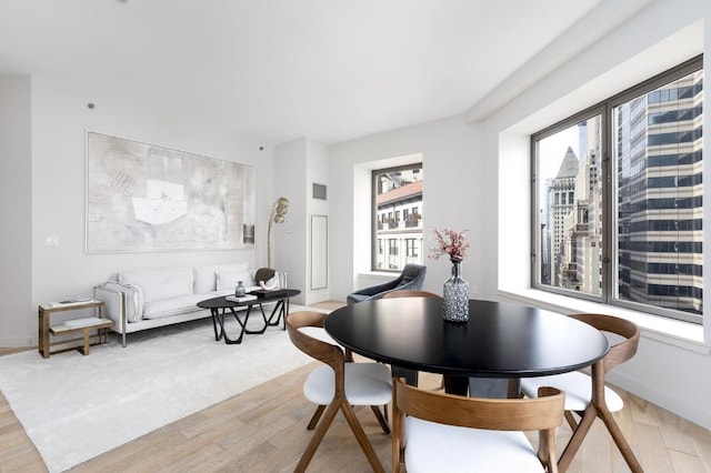 dining space with light hardwood / wood-style flooring and plenty of natural light