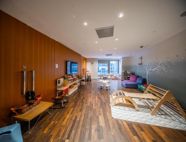 living room with wood finished floors and wood walls