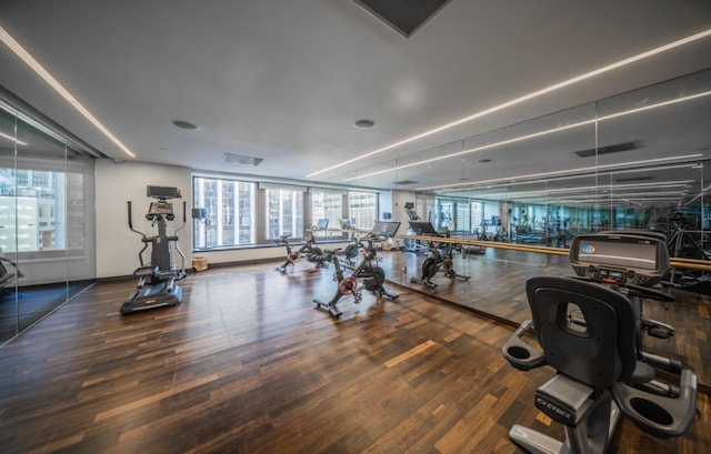 exercise room featuring wood finished floors and baseboards