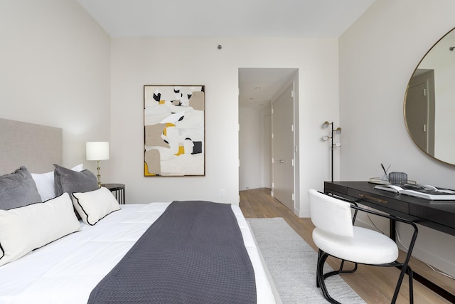 bedroom featuring wood finished floors and a desk