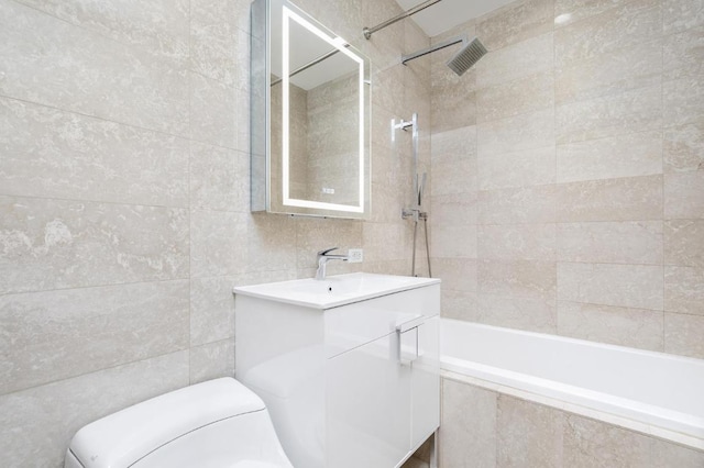 full bath featuring vanity, visible vents, tile walls, toilet, and tiled shower / bath