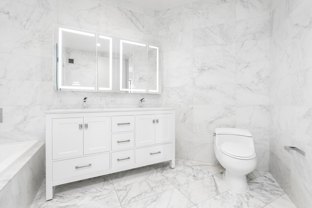 full bath with toilet, tile walls, a bathtub, double vanity, and marble finish floors