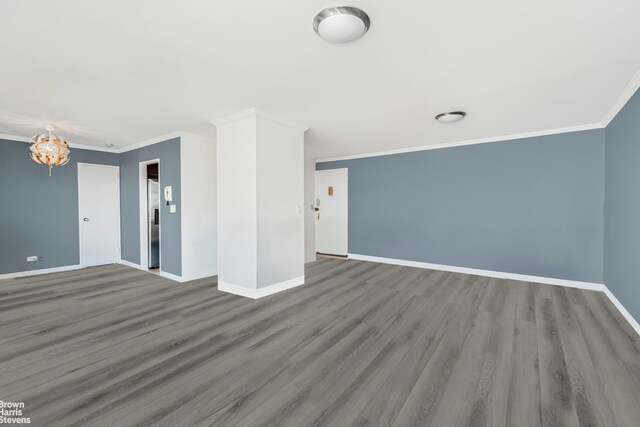 unfurnished room featuring baseboards, wood finished floors, and ornamental molding