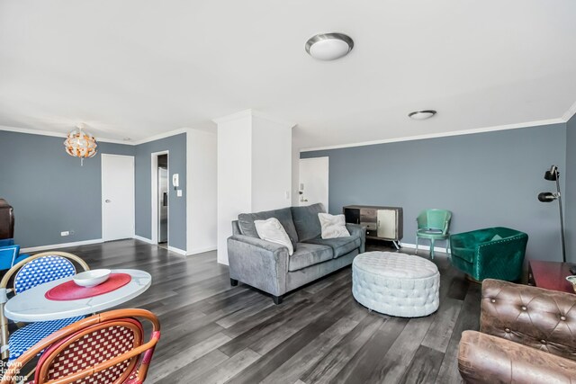 living area featuring an inviting chandelier, crown molding, baseboards, and wood finished floors