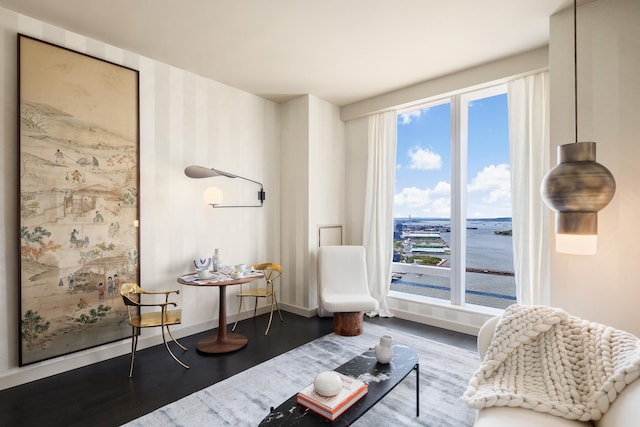 sitting room featuring baseboards, a healthy amount of sunlight, and wood finished floors