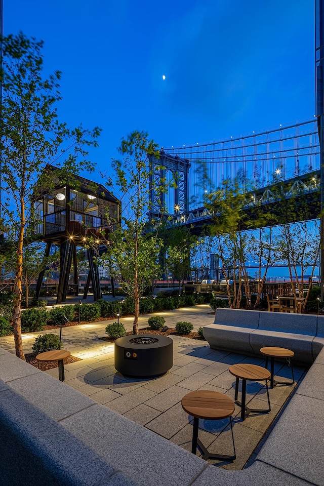 view of community featuring a patio area, playground community, and an outdoor fire pit