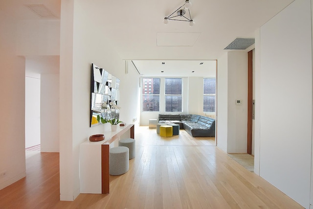 corridor featuring visible vents and light wood finished floors