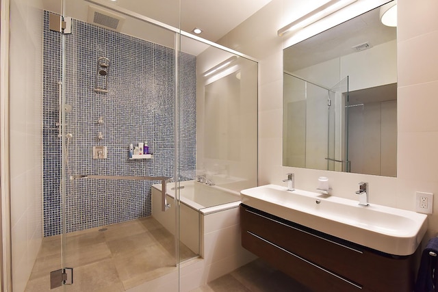 full bathroom featuring double vanity, visible vents, a shower stall, and a sink