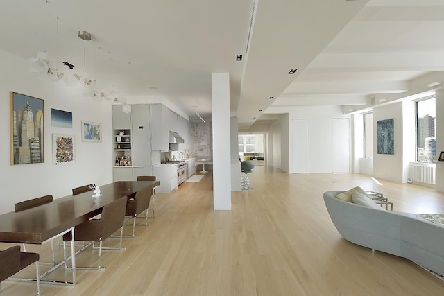 living room featuring radiator heating unit and light wood-style floors