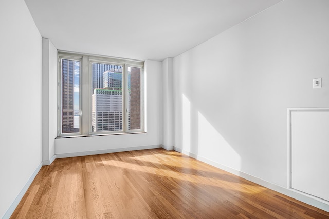 empty room with baseboards and wood finished floors