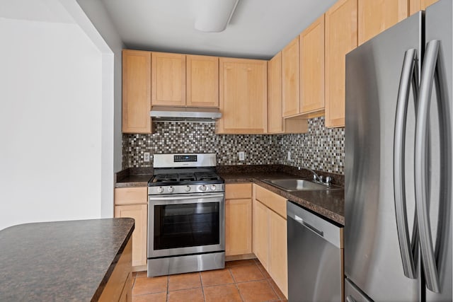 kitchen with under cabinet range hood, appliances with stainless steel finishes, light brown cabinetry, and a sink