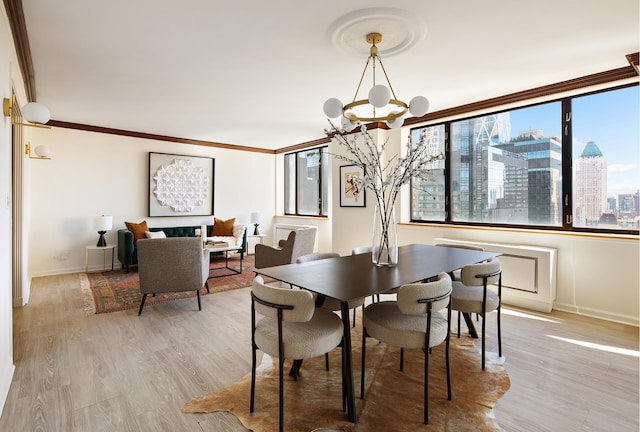 dining room featuring baseboards, a notable chandelier, a city view, and light wood finished floors