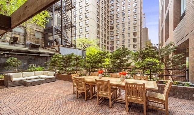 view of patio with stairs, a view of city, outdoor dining area, and an outdoor hangout area