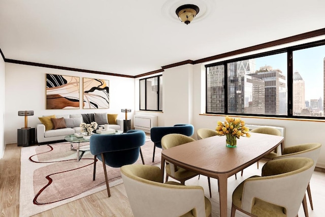 dining space featuring a view of city, light wood-type flooring, and crown molding