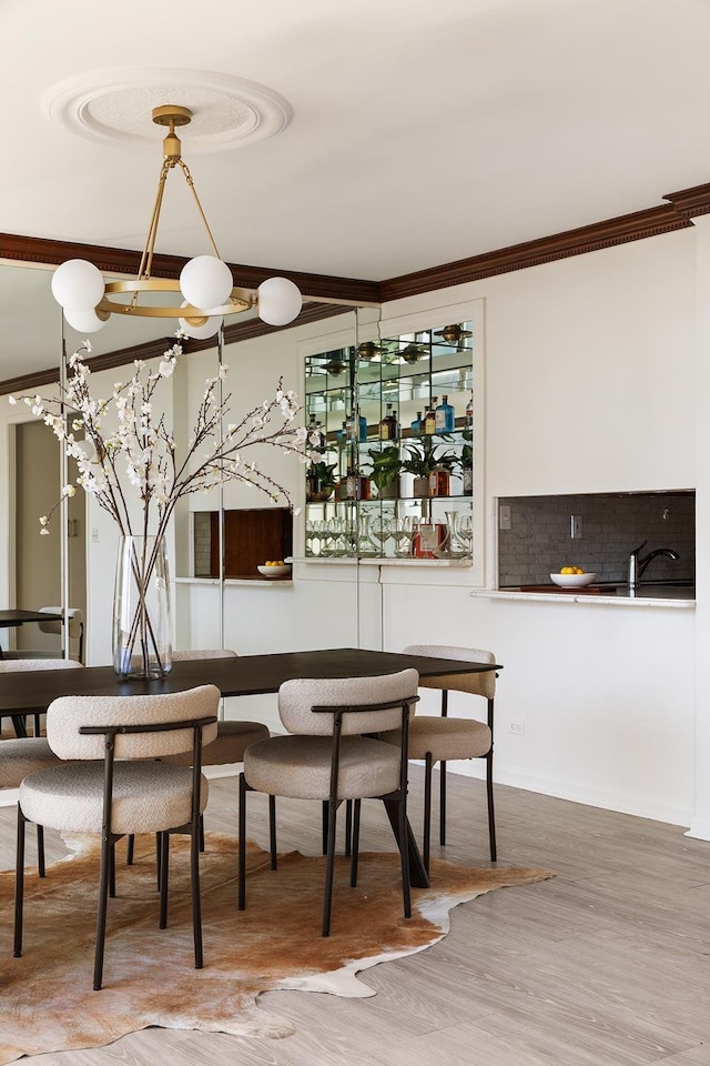 dining space with ornamental molding and wood finished floors