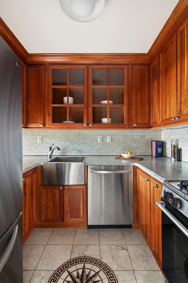 kitchen with tasteful backsplash, glass insert cabinets, appliances with stainless steel finishes, brown cabinetry, and a sink