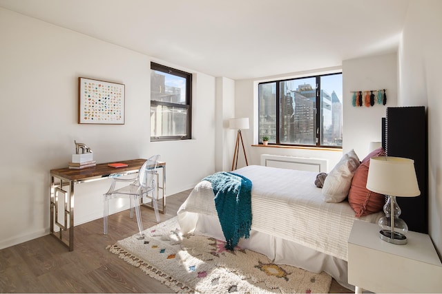 bedroom featuring baseboards, multiple windows, and wood finished floors