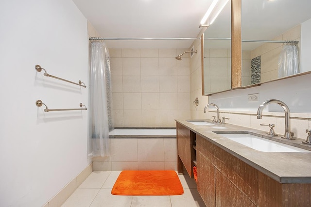 bathroom featuring tile patterned flooring, double vanity, tiled shower / bath combo, and a sink