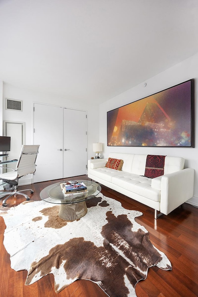 living area with visible vents and wood finished floors