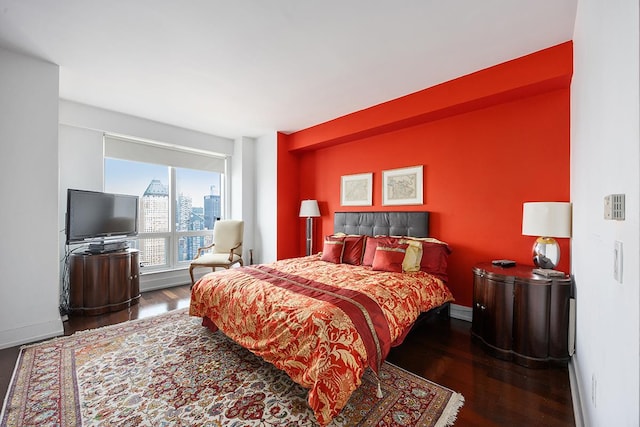 bedroom with wood finished floors and baseboards