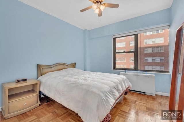 bedroom with light parquet flooring, radiator, ceiling fan, and crown molding