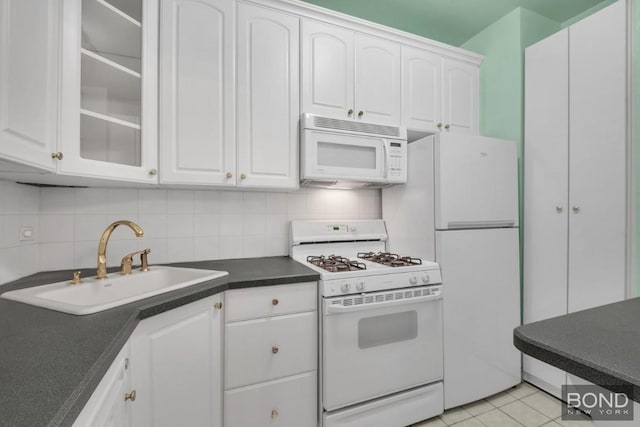 kitchen featuring light tile patterned flooring, sink, white cabinetry, white appliances, and decorative backsplash