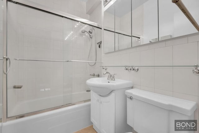 full bathroom with toilet, bath / shower combo with glass door, tile walls, vanity, and decorative backsplash