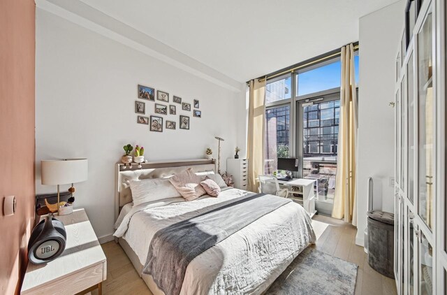 bedroom with light hardwood / wood-style floors and floor to ceiling windows