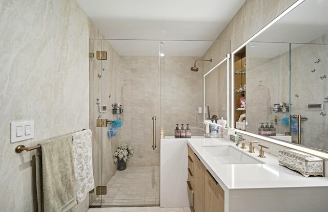 bathroom with vanity, an enclosed shower, and tile walls