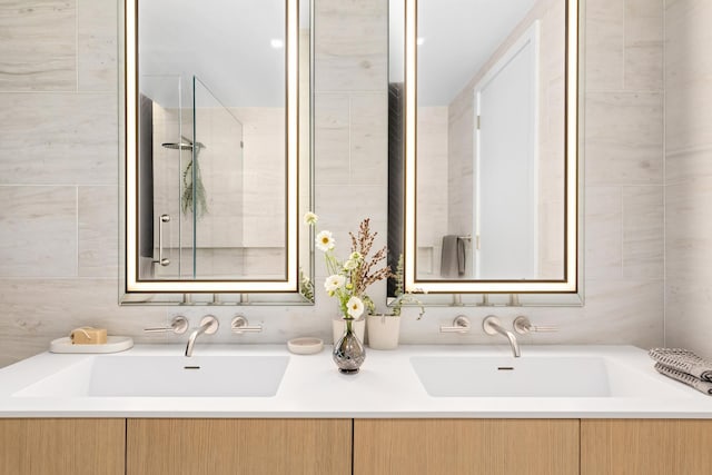 bathroom featuring a sink and tile walls