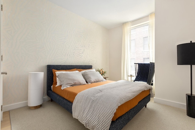 bedroom featuring baseboards and wallpapered walls