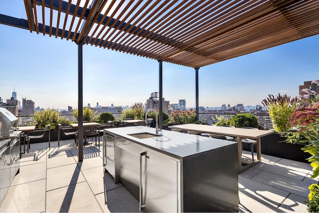 view of patio / terrace featuring an outdoor kitchen, outdoor dry bar, a sink, a pergola, and a city view