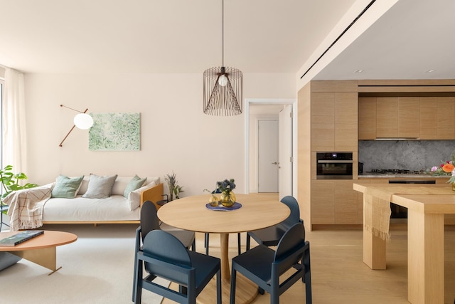 dining room featuring light wood-type flooring and a fireplace