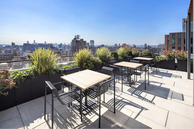 view of patio featuring outdoor dining space and a view of city