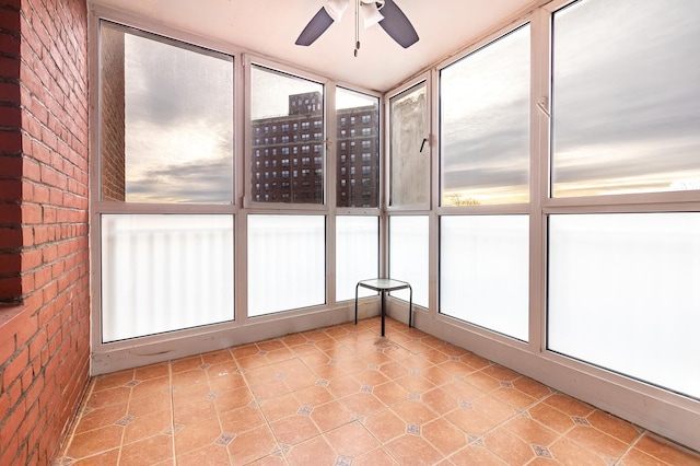 unfurnished sunroom featuring ceiling fan