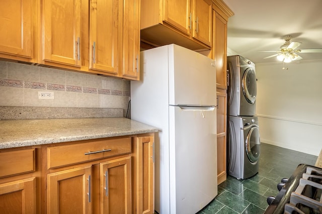 3725 Henry Hudson Pkwy W Unit 6-D, New York City, NY 10463 - kitchen with freestanding refrigerator, stacked washing machine and dryer, ceiling fan, backsplash, and brown cabinetry