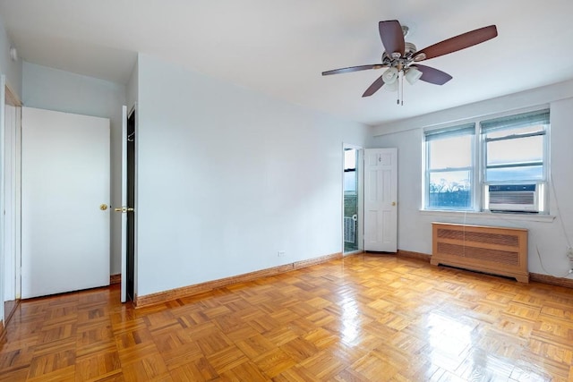 spare room featuring light parquet floors, radiator, cooling unit, and ceiling fan