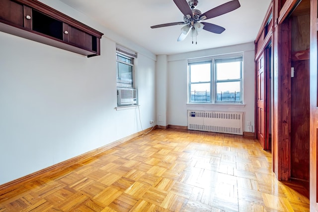 empty room with radiator, ceiling fan, baseboards, and cooling unit