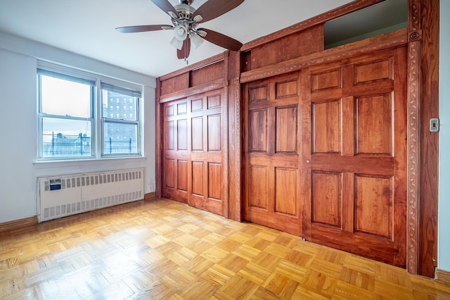 unfurnished bedroom with radiator heating unit, baseboards, and ceiling fan