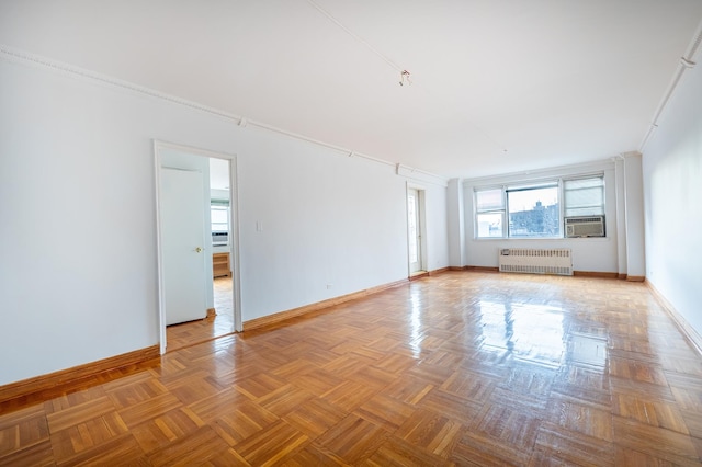 unfurnished room featuring radiator heating unit, baseboards, cooling unit, and ornamental molding