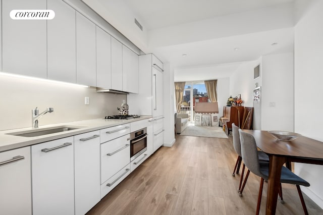 kitchen featuring visible vents, appliances with stainless steel finishes, modern cabinets, and a sink