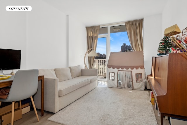 living room featuring a wall of windows, visible vents, and a baseboard heating unit