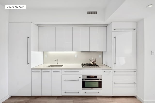 kitchen with modern cabinets, visible vents, stainless steel appliances, and a sink