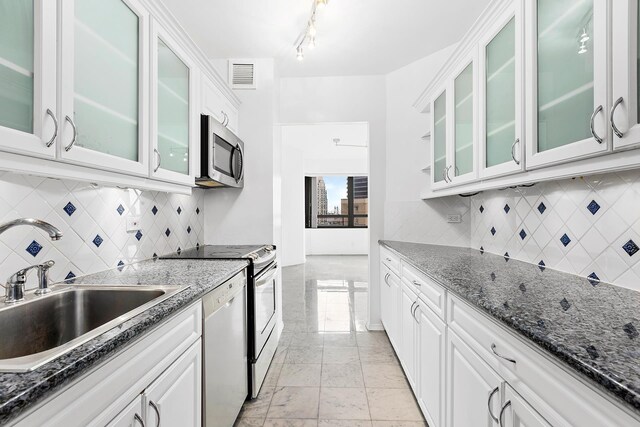 kitchen featuring white cabinetry, sink, dishwashing machine, and range with electric stovetop