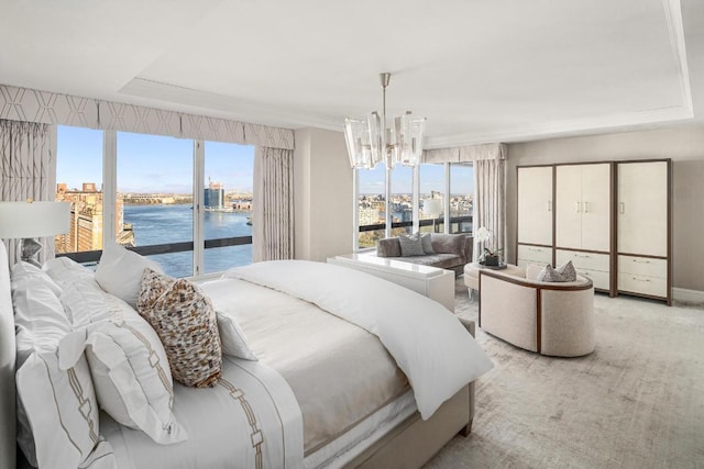 bedroom featuring a water view, an inviting chandelier, multiple windows, and access to outside