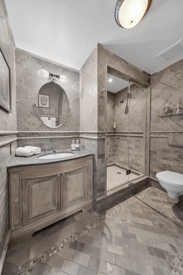 full bath featuring visible vents, toilet, tile walls, and a shower stall