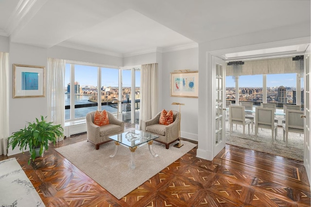 sitting room featuring a water view, crown molding, dark parquet floors, and a wealth of natural light